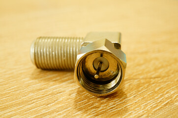 Wall Mural - Closeup shot of a steel metallic adapter on a wooden table