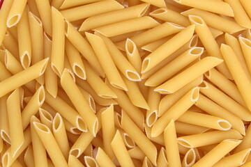 Texture of golden brown pasta in the form of pipes for cooking lunch