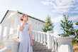 Beautiful girl in tender prom dress on stairs background. Female portrait on spring landscape.