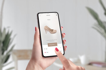 Poster - Shopping shoes online with e-commerce app concept. Woman holding smart phone and touch shop now button