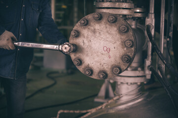 Workers hand holding machine tightening  nut, The mechanic is repairing the machine in the factory, Maintenance man bolting torque in industrial plant