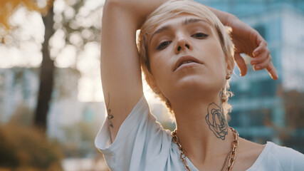 Poster - Portrait of beautiful young short haired blond woman in the park during the sunset. High quality photo