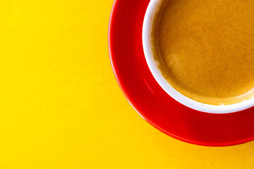 A photo of a red coffee mug on a yellow table