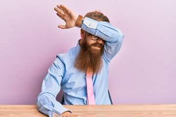 Poster - Young irish redhead man wearing business shirt and tie sitting on the table covering eyes with arm, looking serious and sad. sightless, hiding and rejection concept