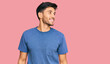 © Krakenimages.com - Young handsome man wearing casual clothes looking away to side with smile on face, natural expression. laughing confident.