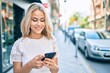 © Krakenimages.com - Young caucasian girl smiling happy using smartphone at street of city.