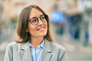 Young hispanic businesswoman smiling happy standing at the city.