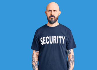 Poster - Young handsome man wearing security t shirt relaxed with serious expression on face. simple and natural looking at the camera.