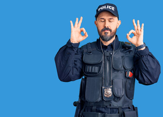 Poster - Young handsome man wearing police uniform relaxed and smiling with eyes closed doing meditation gesture with fingers. yoga concept.