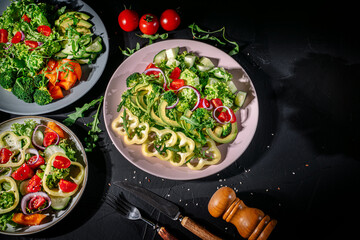 Wall Mural - Healthy vegetable salad of fresh tomato, green leaves mix and vegetables. Top view on dark bacground. Diet menu