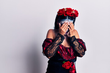 Canvas Print - Young woman wearing mexican day of the dead makeup with sad expression covering face with hands while crying. depression concept.