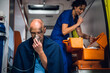 © Anna Kosolapova - Injured man in a blanket is getting first aid in an ambulance car.