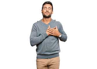 Sticker - Handsome hispanic man wearing casual clothes smiling with hands on chest with closed eyes and grateful gesture on face. health concept.