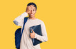 © Krakenimages.com - Young african amercian man wearing student backpack holding binder stressed and frustrated with hand on head, surprised and angry face