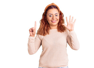 Young latin woman wearing casual clothes and diadem showing and pointing up with fingers number six while smiling confident and happy.