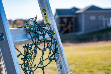 Selective focus on Christmas lights hanging off a ladder rung