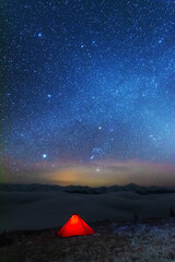 Wall Mural - space starry nights with a bright milky way on the backdrop of tourists with tents.