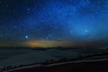 Wall Mural - space starry nights with a bright milky way on the backdrop of tourists with tents.