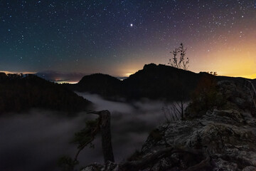 Wall Mural - A beautiful starry night in the mountains on top with beautiful scenery and fog.	