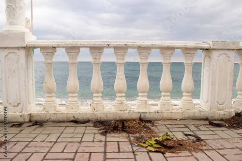 Fotomural Beautiful white balusters supporting the railing on the embankment in Koktebel in Crimea against the background of the sea and overcast sky