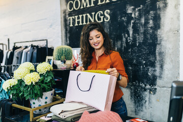 Wall Mural - Beautiful female seller working in exclusive boutique or store.