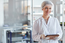 Waist Up Portrait Of Young Female Scientist Holding Digital Tablet And Smiling At Camera While Standing In Medical Laboratory, Copy Space