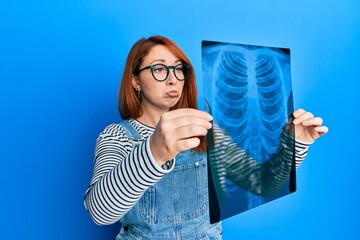 Canvas Print - Beautiful redhead woman holding chest radiography depressed and worry for distress, crying angry and afraid. sad expression.