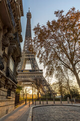 Paris, France - November 26, 2020: A back alley in Paris showcasing the architecture of the buildings with the Eiffel Tower in the background at sunset