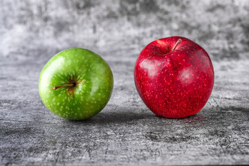 Green and red apples on blackboard or chalkboard background. Bright fruit composition. Close-up on a gray background.