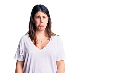 Poster - Young beautiful brunette woman wearing casual t-shirt depressed and worry for distress, crying angry and afraid. sad expression.