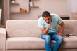 © Elnur - Young man coughing at home during pandemic