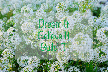 inspirational quote “ dream it believe it build it” on beautiful flower background.