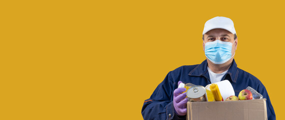 Delivery man puts products in a paper bag and carton box. selective focus. volunteer is wearing special clothing, a protective medical mask and rubber gloves. Service quarantine pandemic coronavirus