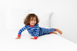 © Lisa Tichané - Smiling toddler boy playing on white bed