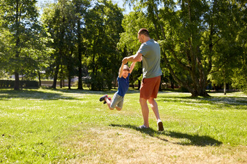 Wall Mural - family, fatherhood and people concept - happy father with little son playing in summer park