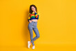 Full length photo of charming girl arm neck pocket abdomen wear striped cropped sweater jeans footwear isolated yellow color background