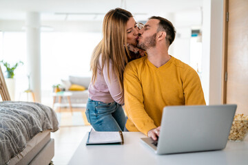 Poster - Mother playing with her kid while dad is working on a laptop.