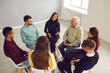 © Studio Romantic - People of all ages sit in a circle at a support group meeting and communicate with each other.