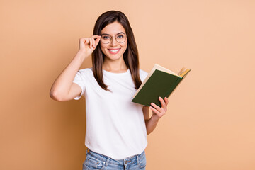 Sticker - Photo portrait of girl wearing eyewear smiling reading book studying in college isolated pastel beige color background