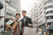 © imtmphoto - young asian couple traveler shopping in hong kong standing on street with paper bags