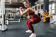 © Drobot Dean - Smiling athletic sportswoman doing exercise while working out in gym