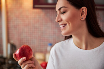 Wall Mural - Pleased lady checking out a delicious apple