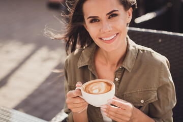 Poster - Photo portrait of cheerful woman enjoying nice cup of coffee with milk art holding in two hands