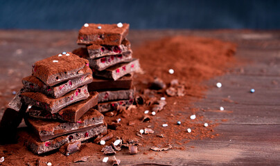 Organic food snack tasty sweet dessert milk dark chocolate bar macro closeup broken slide piece and fruit orange raspberry hazelnut nuts on cocoa cacao powder wooden table for new year Christmas gift