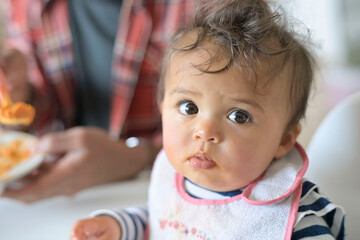 Portrait of 8-month-baby girl eating yoghurt