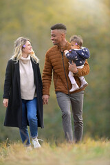 Young family walking together outside in countryside