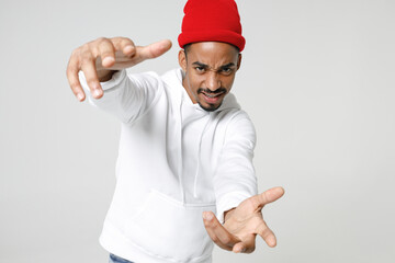 Concerned young african american man 20s years old wearing basic casual streetwear hoodie standing reach out stretching hands looking camera isolated on white colour wall background, studio portrait.