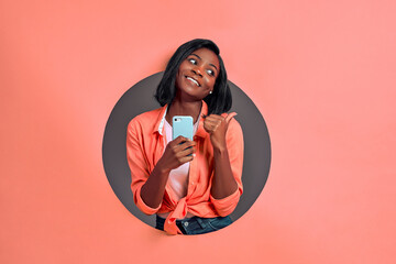 young afro american woman texting using smartphone over isolated background pointing and showing wit