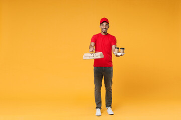 Wall Mural - Full length delivery employee african man in red cap blank print t-shirt uniform work courier dealer service concept hold give food order pizza cardboard boxes isolated on yellow background studio