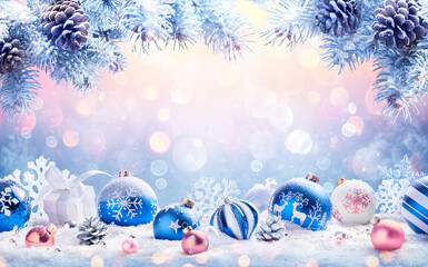 Wall Mural - abstract christmas card - baubles on snow with fir branches and defocused snowfall in background